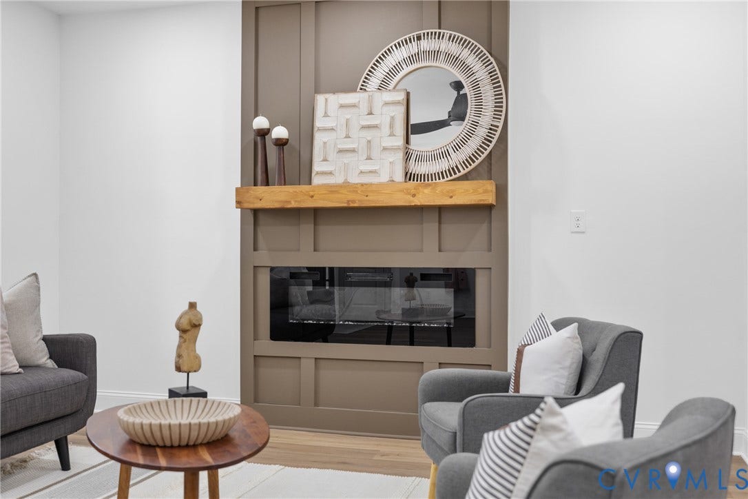 Fireplace with a wood-finish mantel and integrated glass-front firebox, set within a paneled wall feature