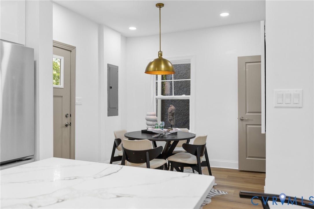 White walls with recessed lighting, wood-finish flooring, a brass pendant light, and a window with white trim