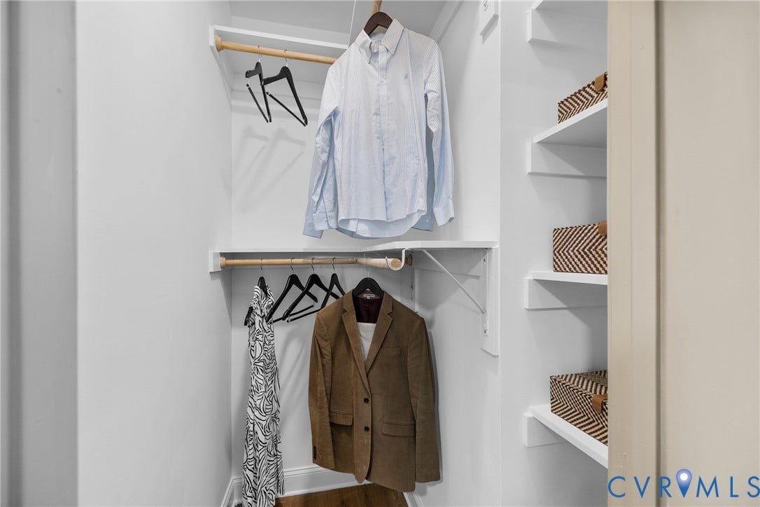 Built-in shelving, two hanging rods, and white wall finishes