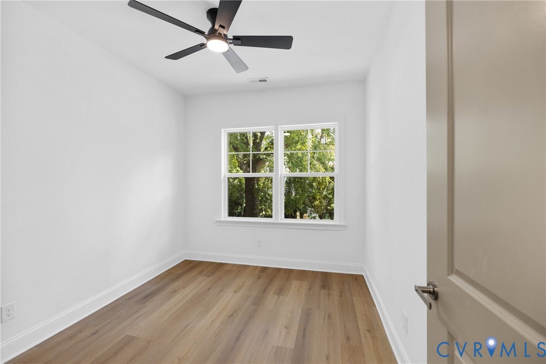 Wood-finish flooring, white walls, and a contemporary ceiling fan with integrated lighting