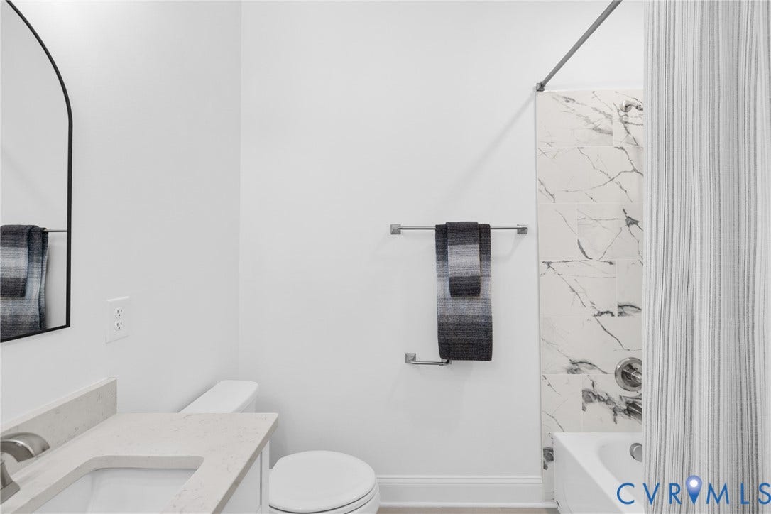 White vanity with a light-toned countertop, undermount sink, and brushed nickel faucet