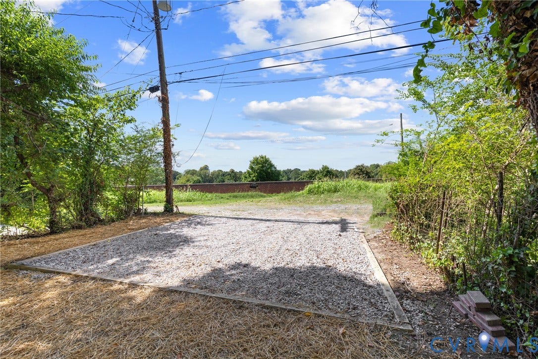 Gravel parking area bordered by wood planks