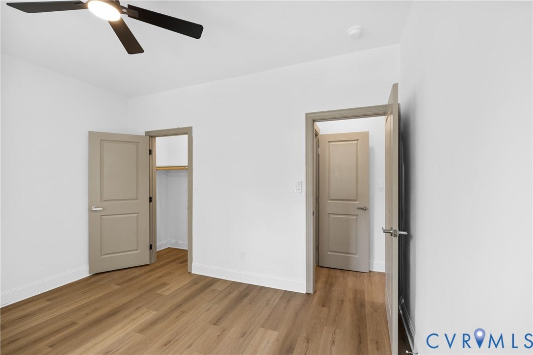 Wood-finish flooring, white walls, and a contemporary ceiling fan with integrated lighting