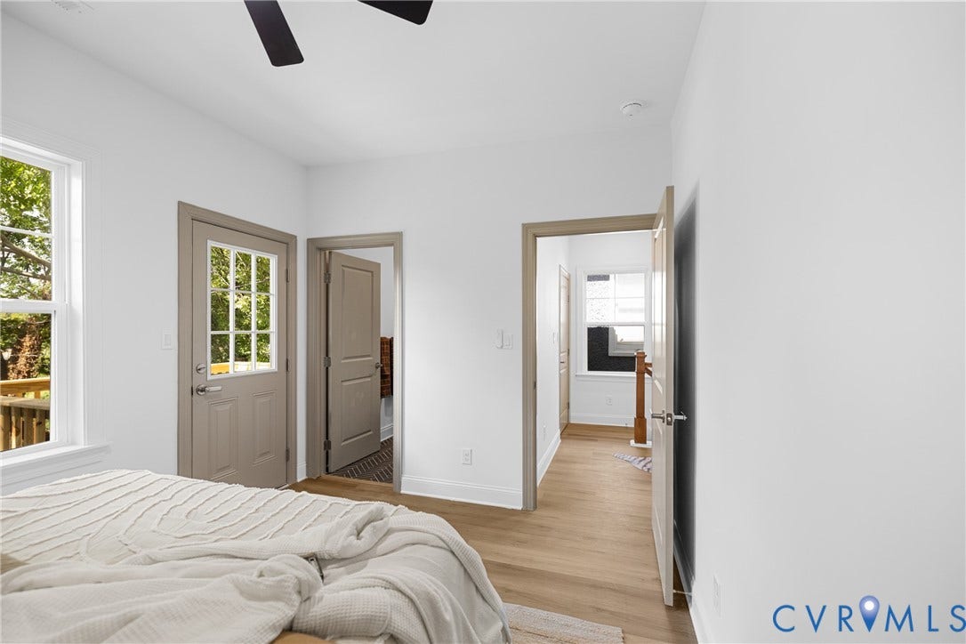 White walls with light wood-finish flooring, a ceiling fan, and a glass-paneled exterior door