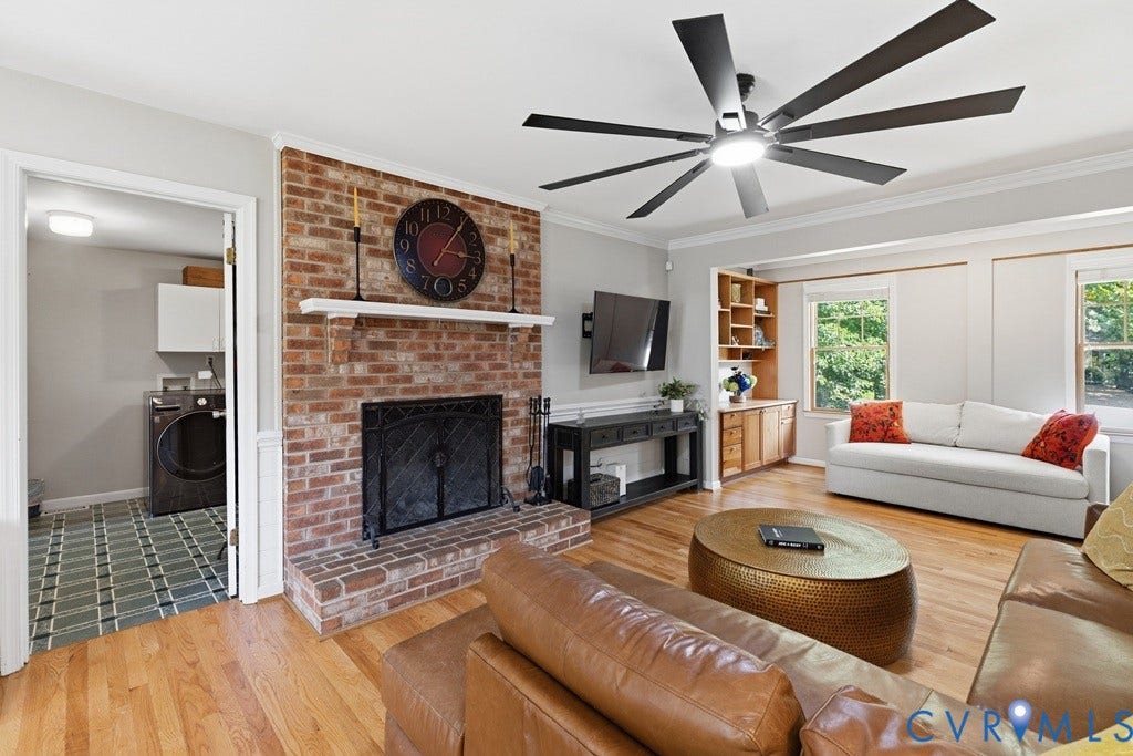 2416 Mountainbrook Drive, Crown Grant, Henrico, VA 23233 Living area featuring wood-finish flooring, a brick fireplace with a white mantel, built-in shelving, and a large ceiling fan with light