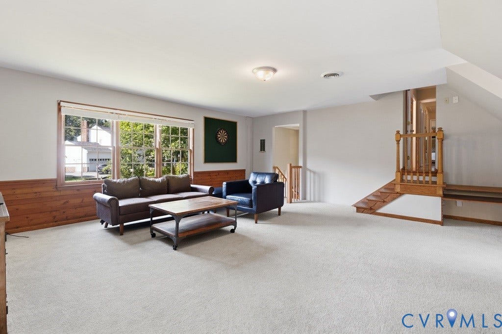 2416 Mountainbrook Drive, Crown Grant, Henrico, VA 23233 Carpeted room featuring a multi-pane window, wood paneling, and a staircase with wood railing