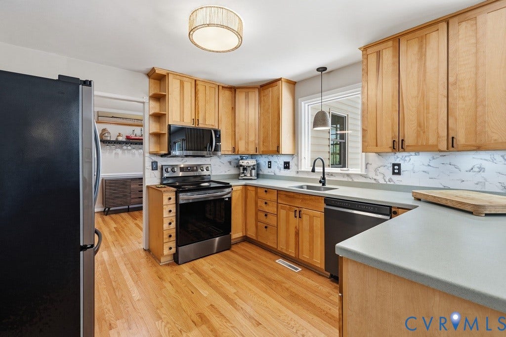 2416 Mountainbrook Drive, Crown Grant, Henrico, VA 23233 Wood-finish flooring, light wood cabinetry, white stone backsplash, and dark stainless steel appliances