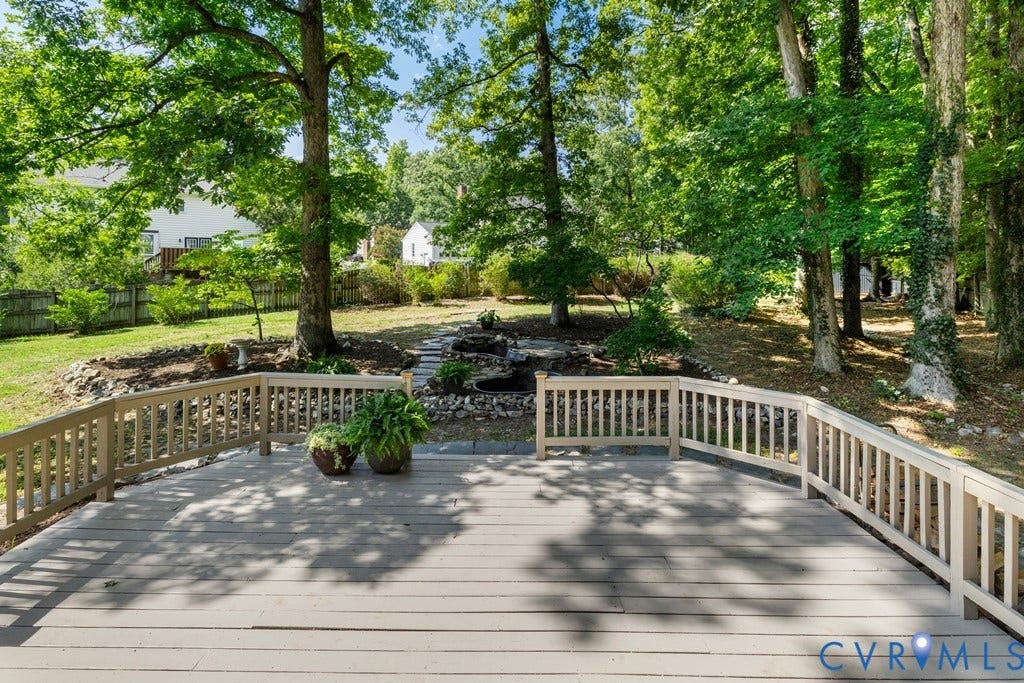 2416 Mountainbrook Drive, Crown Grant, Henrico, VA 23233 Expansive outdoor deck with railing, featuring a terraced backyard with a rock garden and mature trees