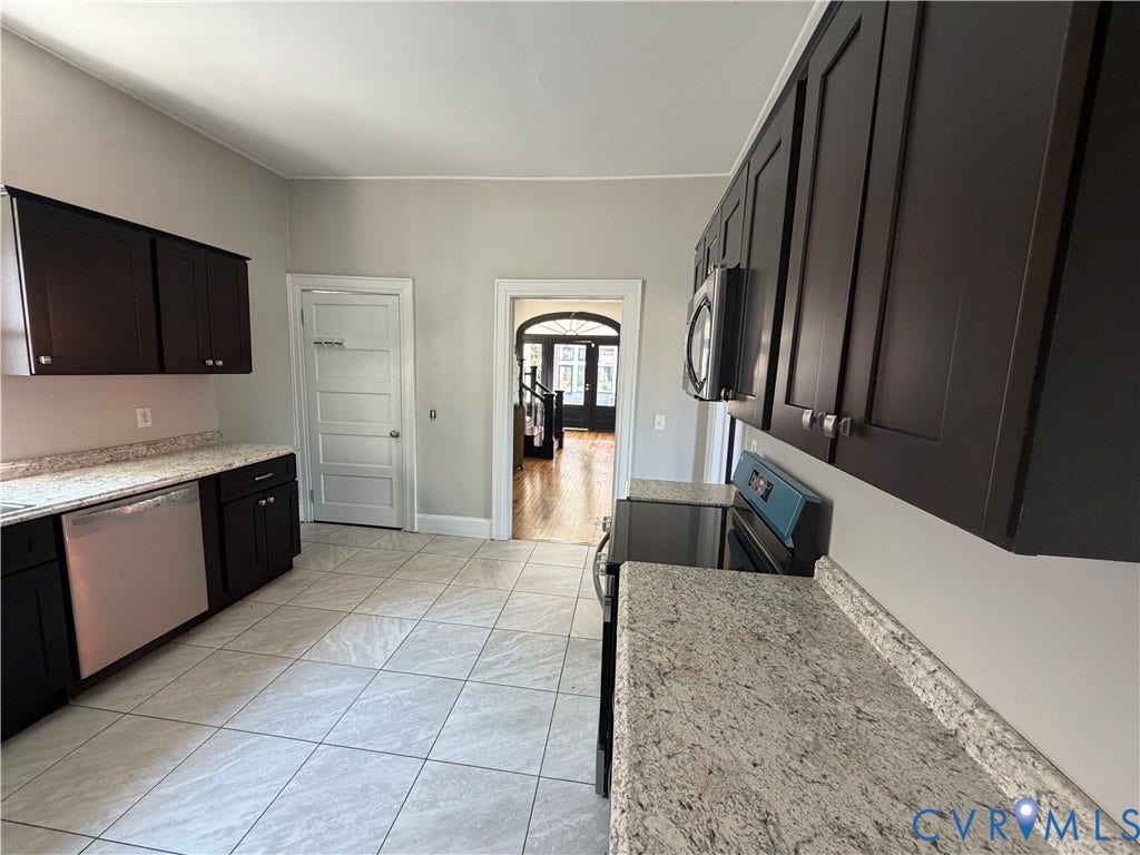 715 High Street, Petersburg, VA 23803 Kitchen with dark wood cabinetry, light-toned countertops, stainless steel appliances, and tiled flooring
