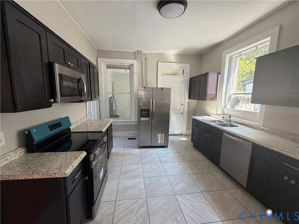 715 High Street, Petersburg, VA 23803 Kitchen featuring dark cabinetry, light-toned countertops, stainless steel appliances, and tiled flooring