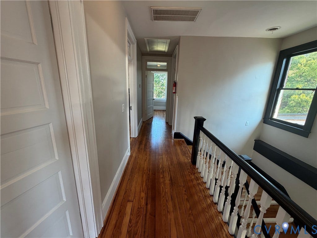 715 High Street, Petersburg, VA 23803 Hardwood flooring, painted interior doors, white trim, painted walls, and a staircase with painted newel posts and balusters