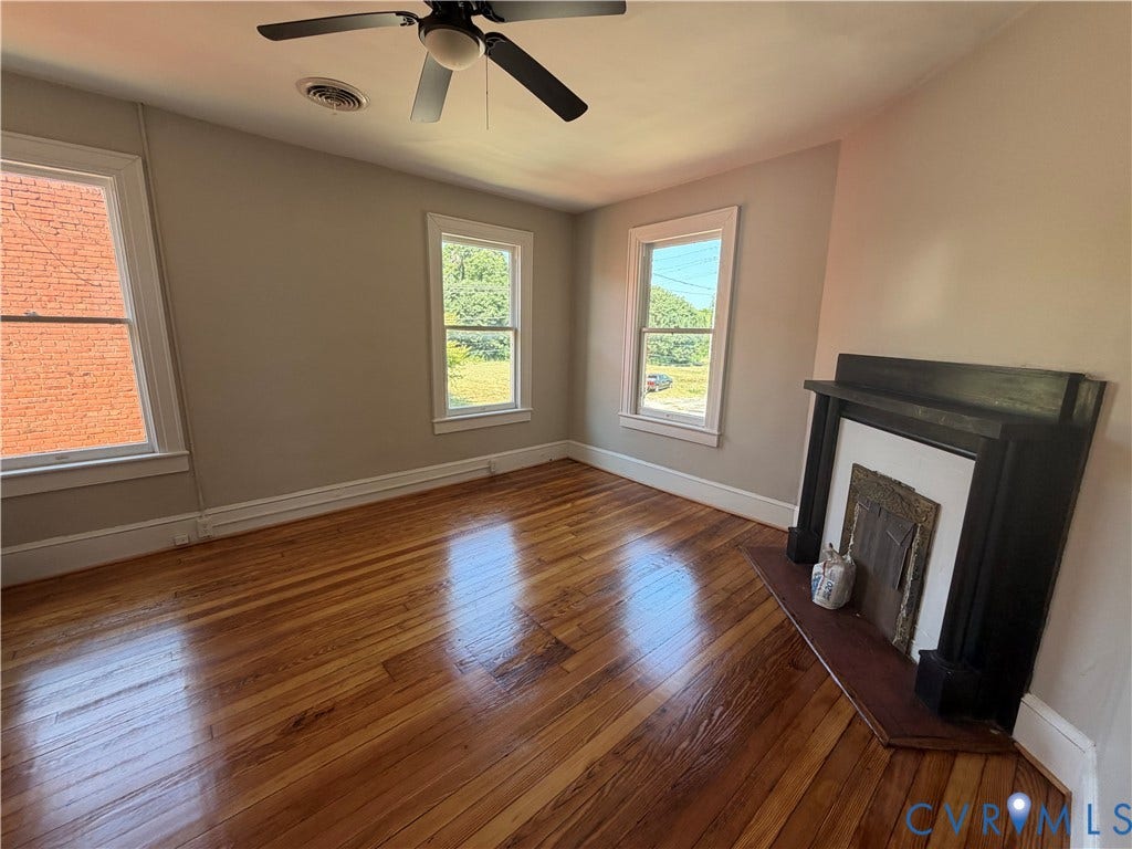 715 High Street, Petersburg, VA 23803 Hardwood flooring, decorative fireplace, multiple windows, ceiling fan, and painted walls