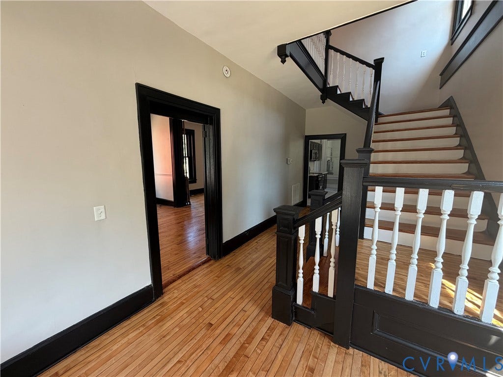 715 High Street, Petersburg, VA 23803 Hardwood flooring, painted trim, and a prominent staircase with decorative balusters