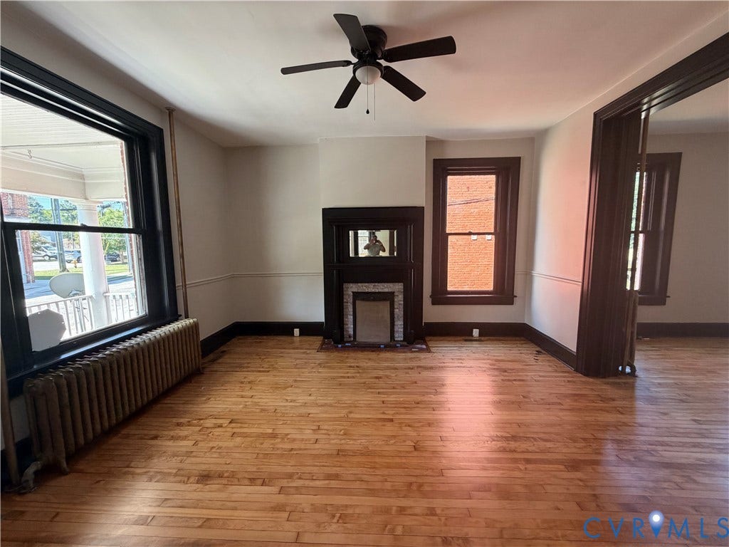 715 High Street, Petersburg, VA 23803 Hardwood flooring throughout, featuring a decorative fireplace with a tile surround, and a ceiling fan
