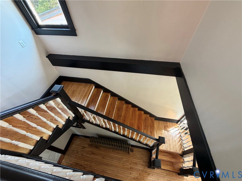 715 High Street, Petersburg, VA 23803 Hardwood flooring and staircase with painted balusters, a dark wood-finish handrail, and trim