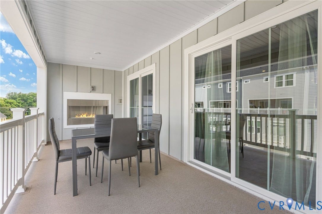 8045 Lake Laurel Lane, #B, Laurel Oak Condos, Glen Allen, VA 23060 Outdoor living space featuring a built-in fireplace, sliding glass doors, white railing, and a textured floor