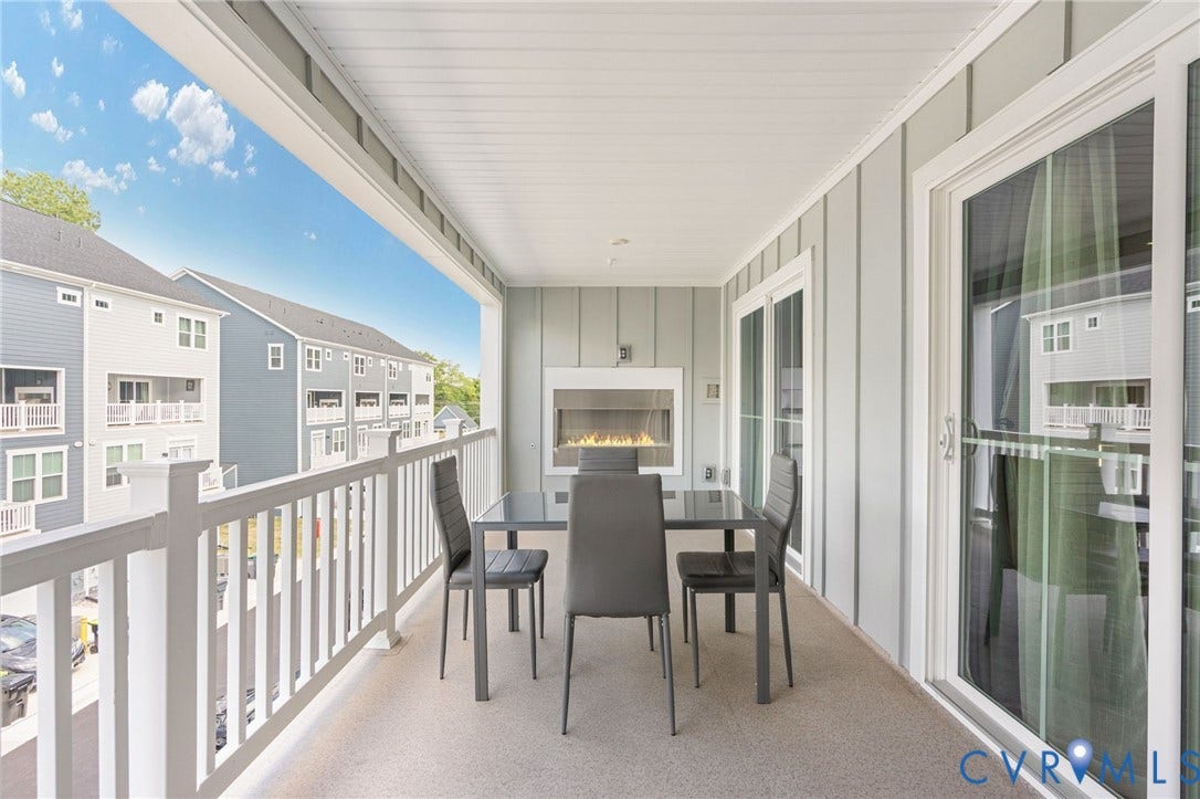 8045 Lake Laurel Lane, #B, Laurel Oak Condos, Glen Allen, VA 23060 Covered balcony featuring a built-in linear fireplace, durable railing, and sliding glass doors