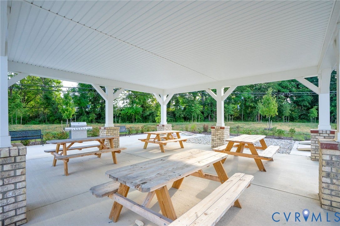 8045 Lake Laurel Lane, #B, Laurel Oak Condos, Glen Allen, VA 23060 Covered outdoor patio with a concrete surface, supported by brick-clad pillars, and featuring multiple picnic tables and a stainless steel grill