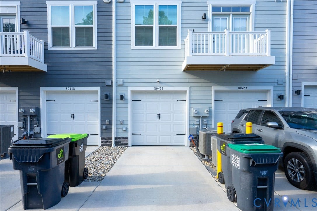 8045 Lake Laurel Lane, #B, Laurel Oak Condos, Glen Allen, VA 23060 Exterior featuring horizontal siding, white-trimmed windows, and white garage doors with decorative hardware