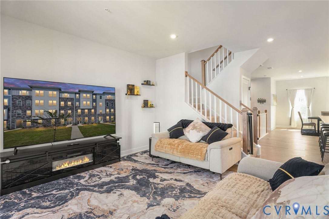 8045 Lake Laurel Lane, #B, Laurel Oak Condos, Glen Allen, VA 23060 Open-concept living space featuring recessed lighting, a modern electric fireplace, light wood-finish flooring, and a staircase with white balusters and wood handrails