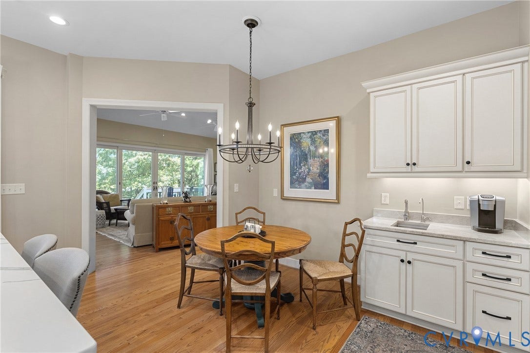 447 Tranquility Road, Reedville, VA 22539 Hardwood flooring throughout, white cabinetry with dark hardware, built-in wet bar with undermount sink, and recessed lighting