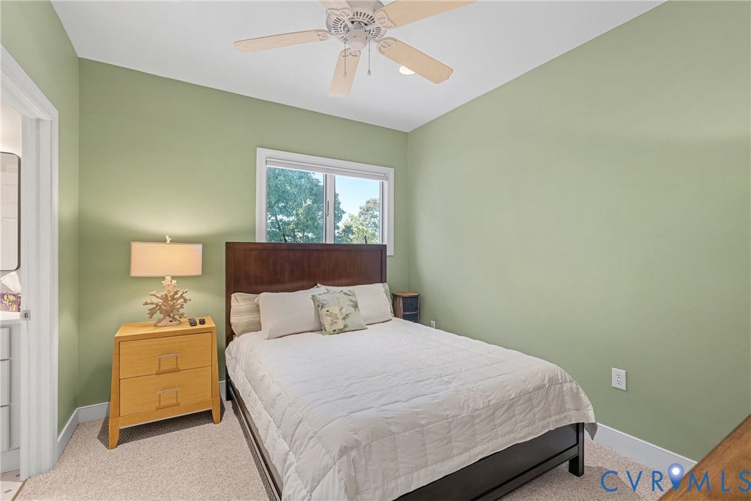 447 Tranquility Road, Reedville, VA 22539 Room featuring a ceiling fan, window with exterior landscaping visible, and carpet flooring