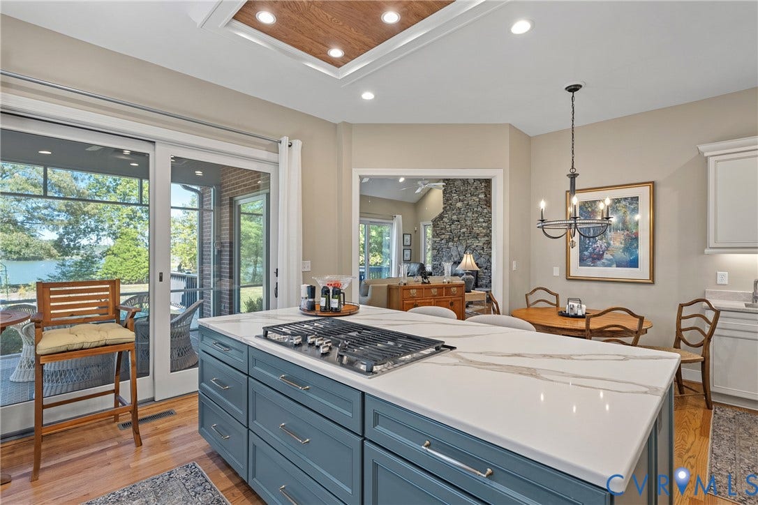 447 Tranquility Road, Reedville, VA 22539 Kitchen featuring a central island with a cooktop, stone countertop, and custom blue cabinetry