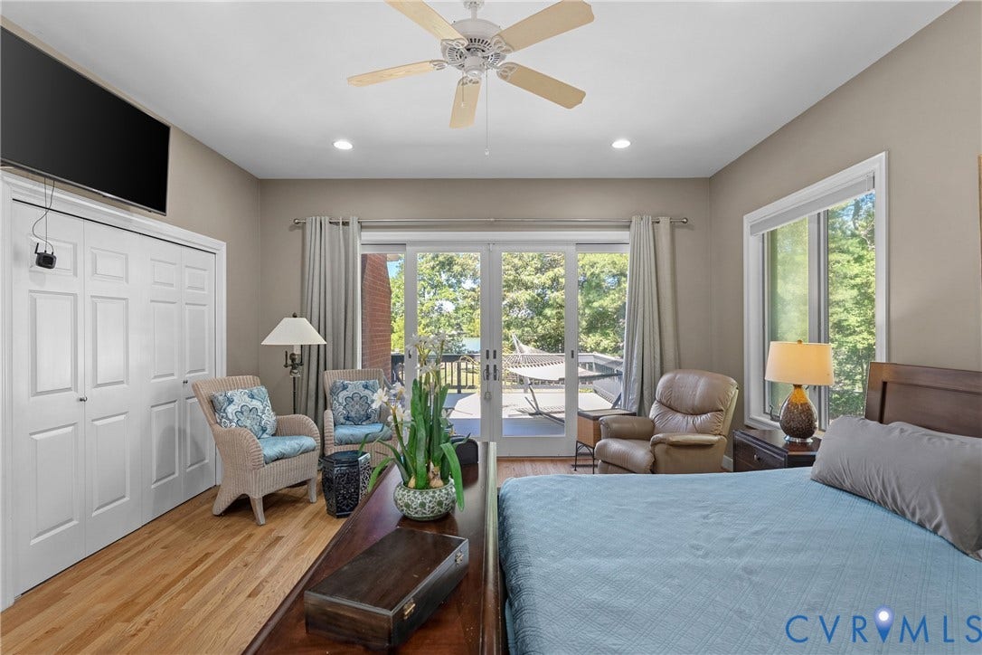 447 Tranquility Road, Reedville, VA 22539 Hardwood flooring, recessed lighting, ceiling fan, bi-fold closet doors, and sliding glass door access to an outdoor deck