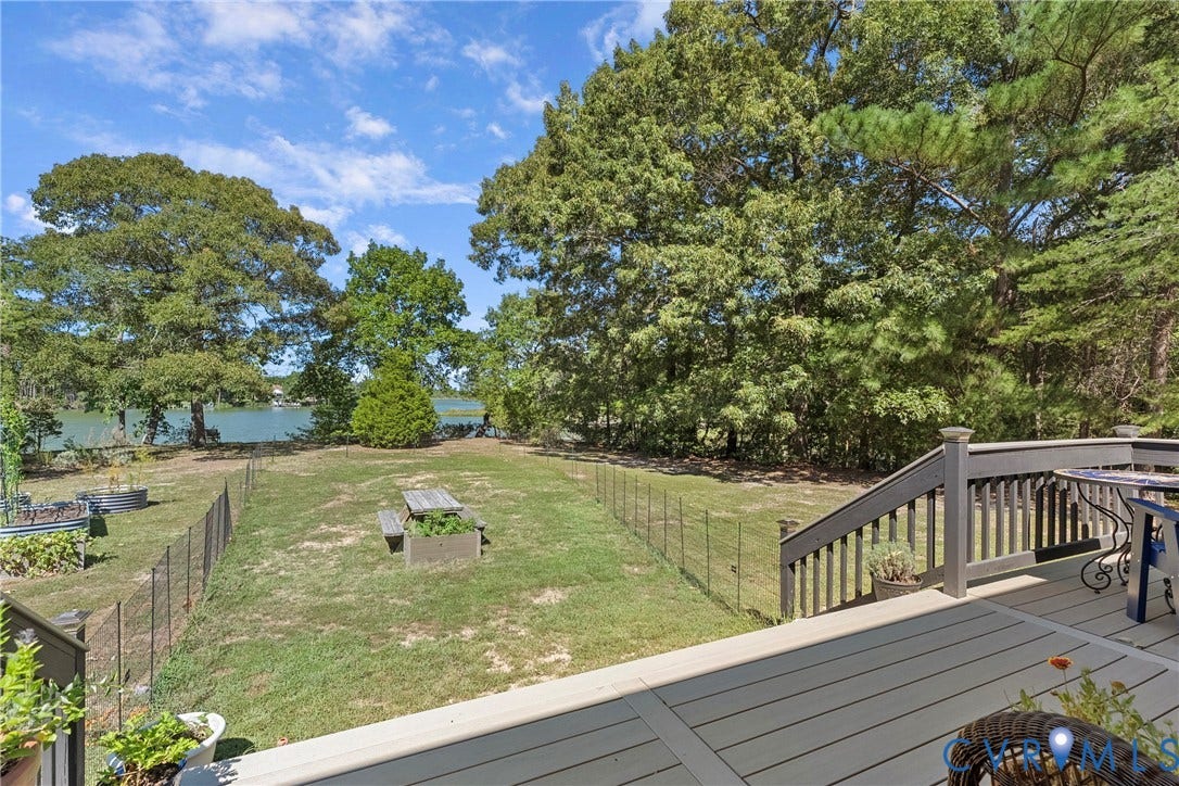 447 Tranquility Road, Reedville, VA 22539 Expansive backyard with a manicured lawn, mature trees, and a body of water in the background