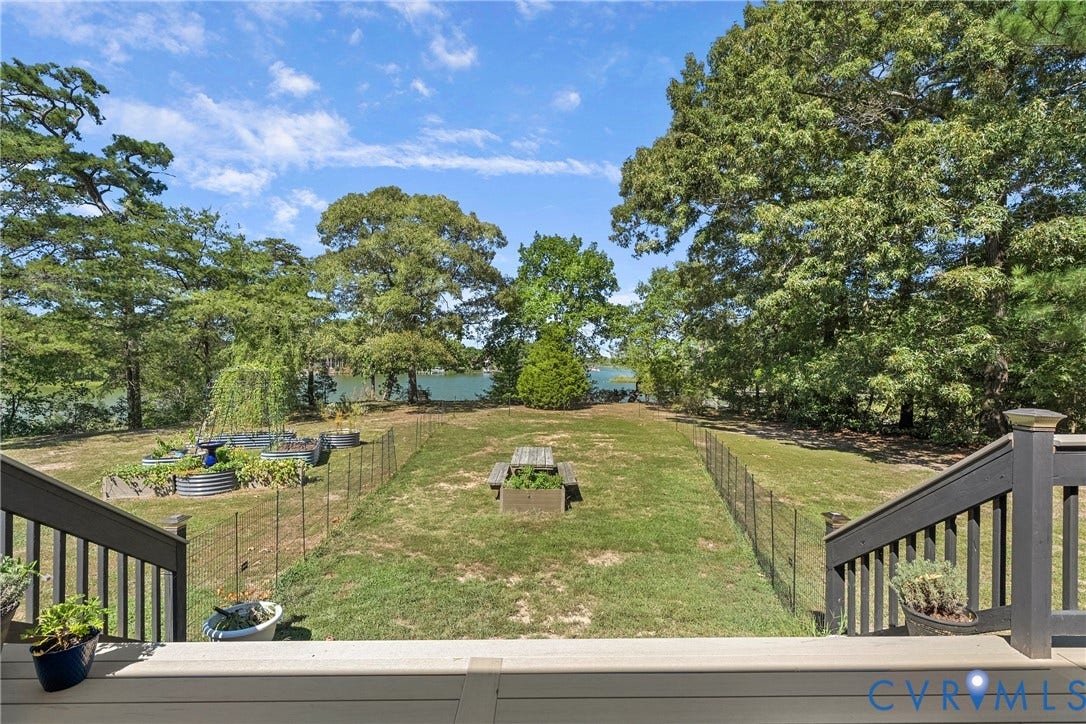 447 Tranquility Road, Reedville, VA 22539 Expansive backyard featuring a sloped lawn, mature trees, and a water backdrop