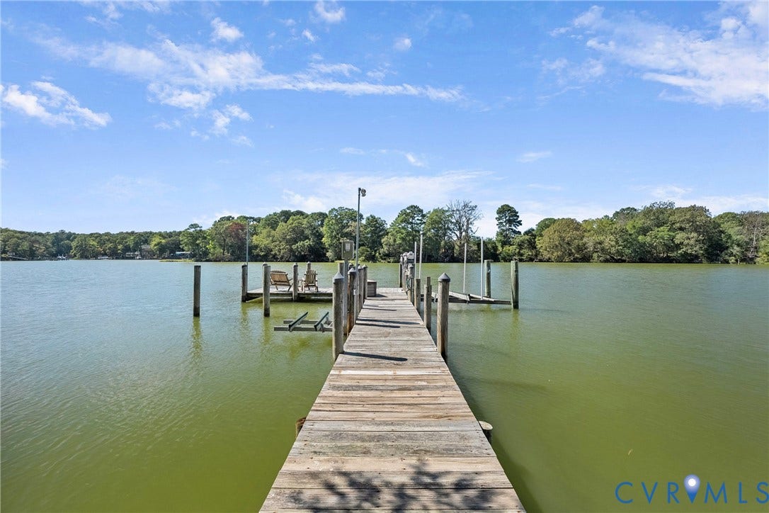 447 Tranquility Road, Reedville, VA 22539 Private dock with wood planking and multiple pilings, featuring an integrated boat lift and clear water access