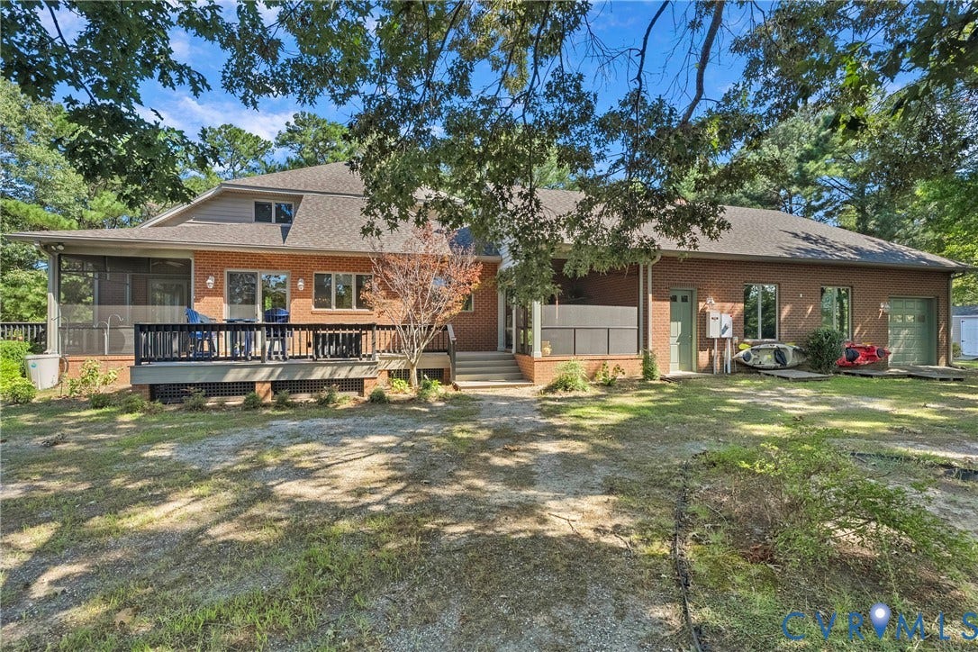 447 Tranquility Road, Reedville, VA 22539 Brick exterior with multiple windows, a screened porch, and an attached wood deck