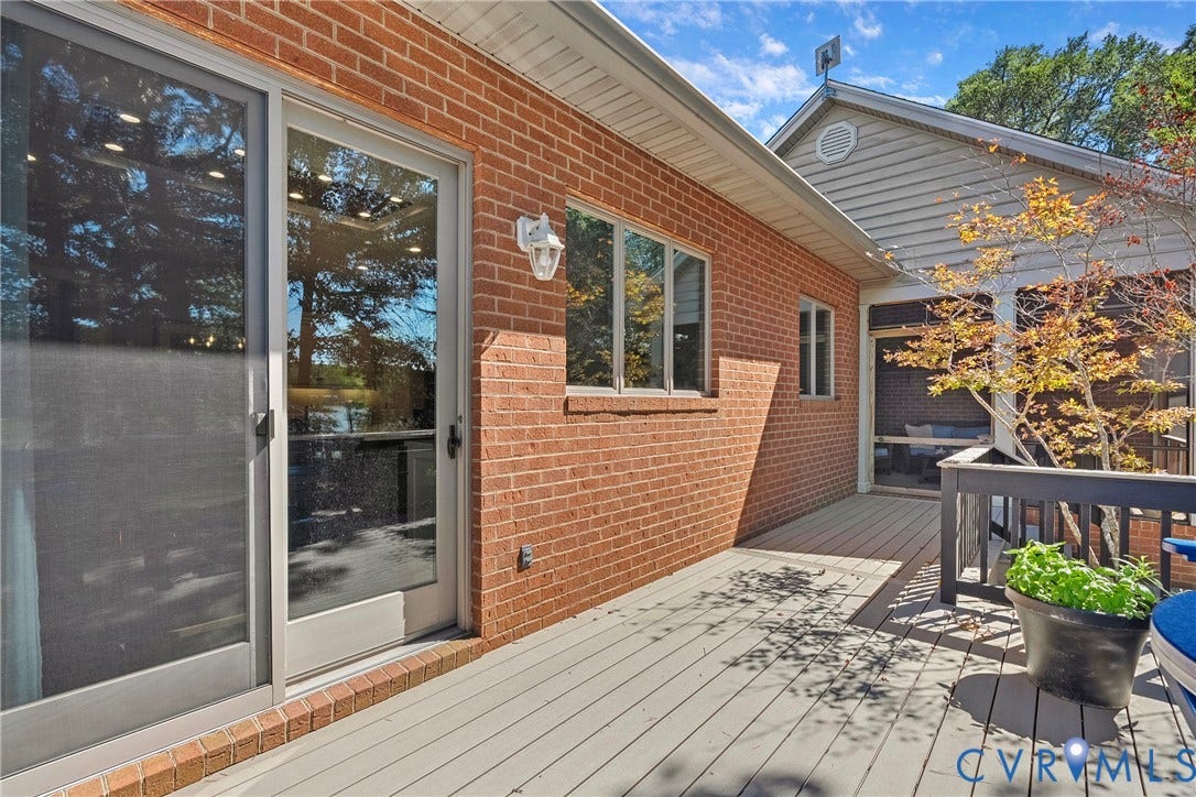 447 Tranquility Road, Reedville, VA 22539 Brick exterior with multiple windows, sliding glass door, composite decking, and a screened porch