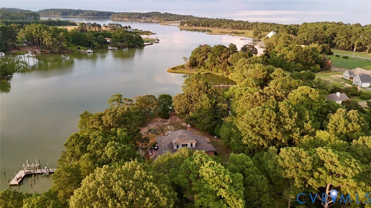 447 Tranquility Road, Reedville, VA 22539 Waterfront property featuring a private dock, surrounded by mature trees and natural landscaping