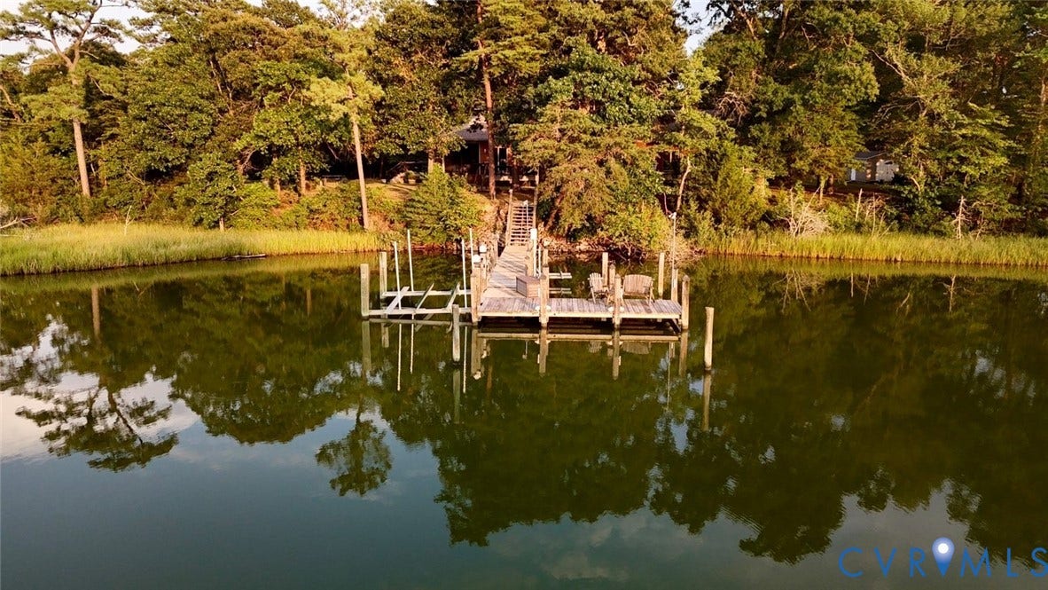 447 Tranquility Road, Reedville, VA 22539 Waterside property featuring a private boat dock, lush treeline, and a tranquil body of water