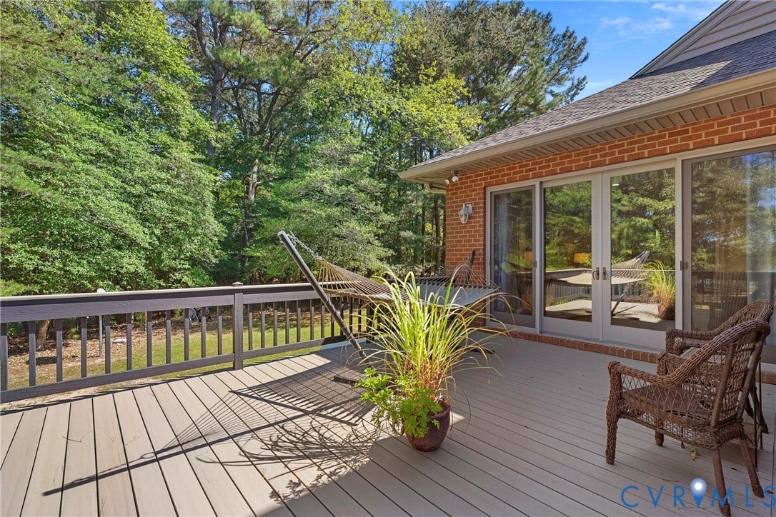 447 Tranquility Road, Reedville, VA 22539 Brick exterior with a composite deck, featuring glass double doors and an exterior wall light