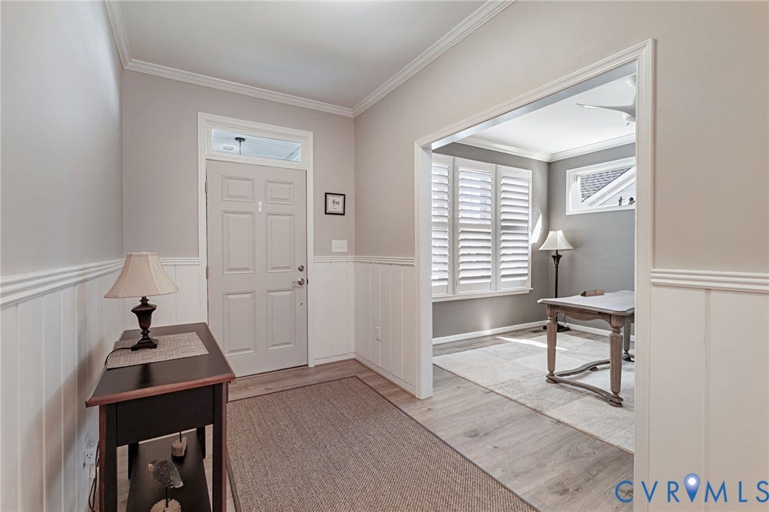 8681 Terroir Lane, Cottages At Viniterra, New Kent, VA 23124 Entryway LVP flooring, wainscoting, crown molding, and a paneled door with transom window