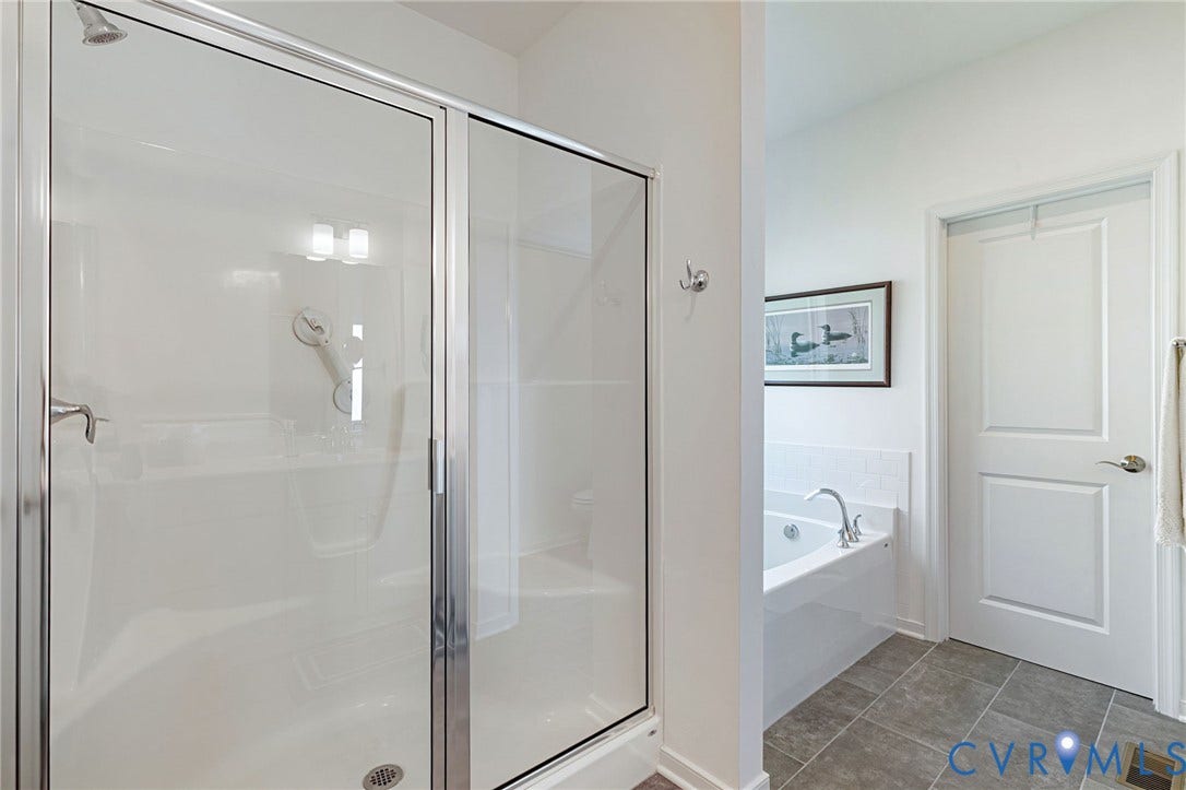 8681 Terroir Lane, Cottages At Viniterra, New Kent, VA 23124 White paneled soaking tub, chrome fixtures, separate glass-enclosed shower, and tiled flooring