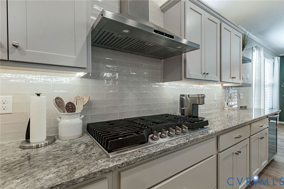 8681 Terroir Lane, Cottages At Viniterra, New Kent, VA 23124 Stainless steel range hood, light gray shaker cabinetry, slab granite countertops, subway tile backsplash, and a built-in gas range