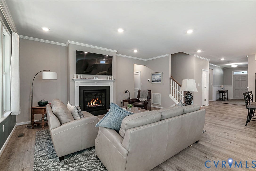 8681 Terroir Lane, Cottages At Viniterra, New Kent, VA 23124 Living area featuring a fireplace with a white mantel, recessed lighting, LVP flooring, and white crown molding