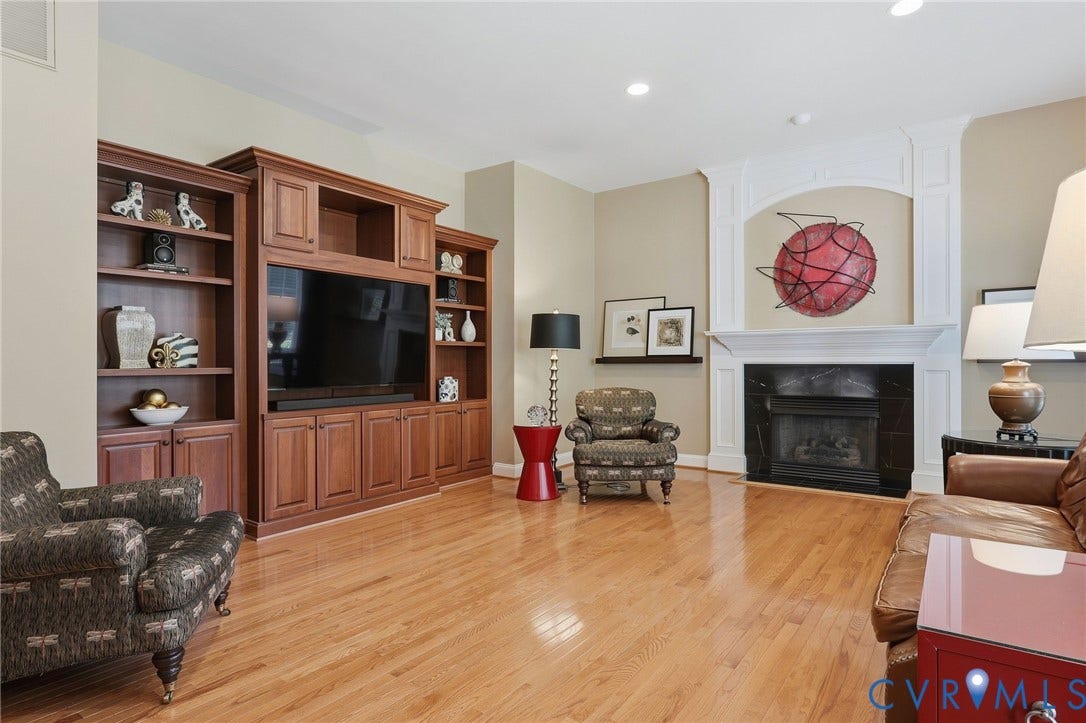 3012 Hedgeway Place, Tarrington, Midlothian, VA 23113 Light wood-finish flooring throughout, built-in entertainment center with shelving, fireplace with dark stone surround, and white decorative mantel