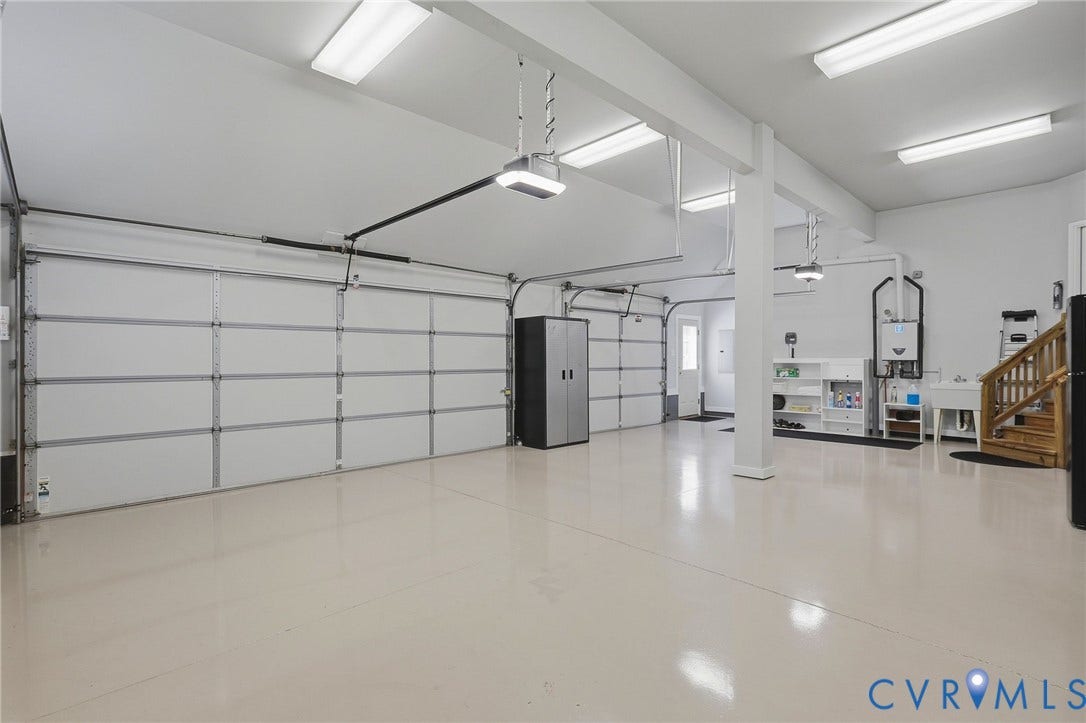 3012 Hedgeway Place, Tarrington, Midlothian, VA 23113 Expansive garage featuring multiple automatic overhead doors, a utility sink, and wood-finish stairs
