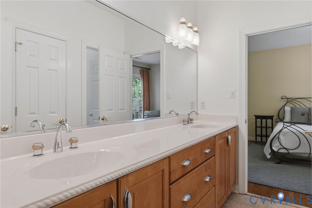 3012 Hedgeway Place, Tarrington, Midlothian, VA 23113 Elongated vanity with dual integrated sinks, chrome fixtures, full-width mirror, and wood-finish cabinetry