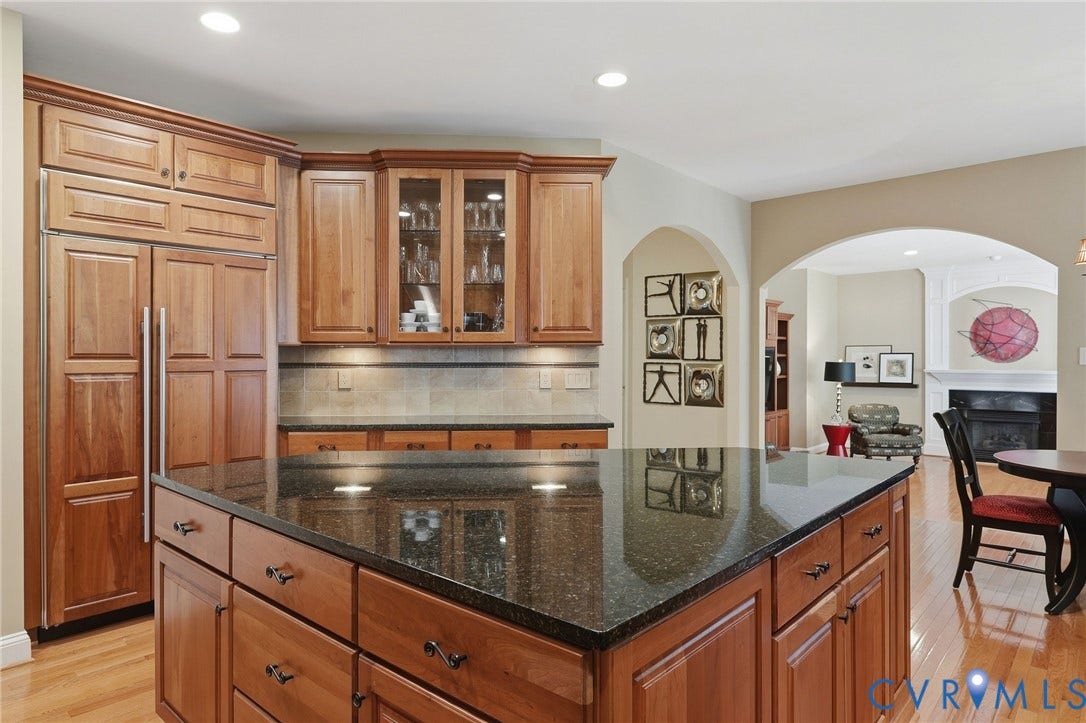 3012 Hedgeway Place, Tarrington, Midlothian, VA 23113 Kitchen featuring wood cabinetry, a large kitchen island with a dark countertop, paneled built-in refrigerator, and wood-finish flooring