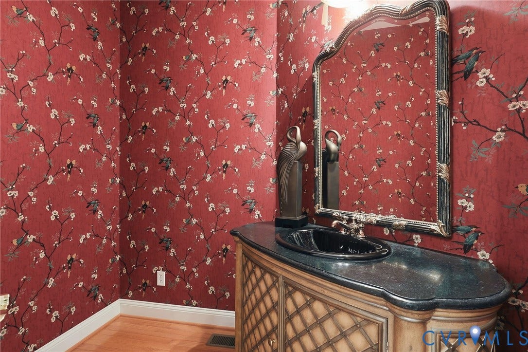 3012 Hedgeway Place, Tarrington, Midlothian, VA 23113 Red patterned wallpaper, ornate mirror, black basin sink, dark countertop, and wood-finish vanity