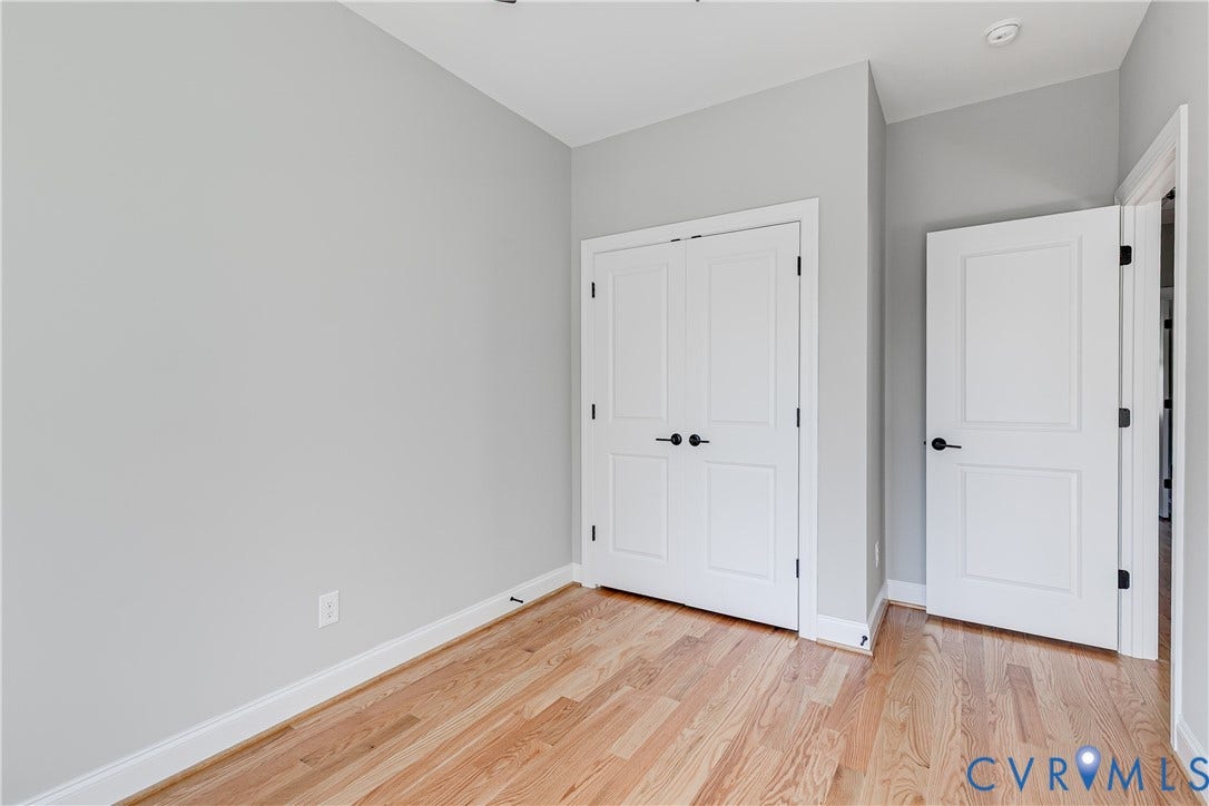 Light wood-finish flooring, crisp white trim, and a recessed ceiling light