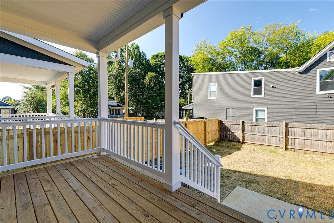 Covered wood-plank deck with white painted railings