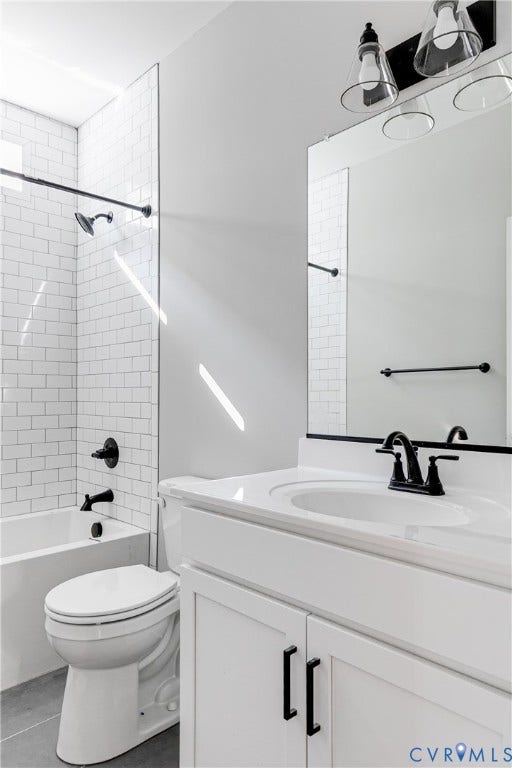 White subway tile shower surround with a built-in tub, white vanity with an integrated sink, and matte black fixtures