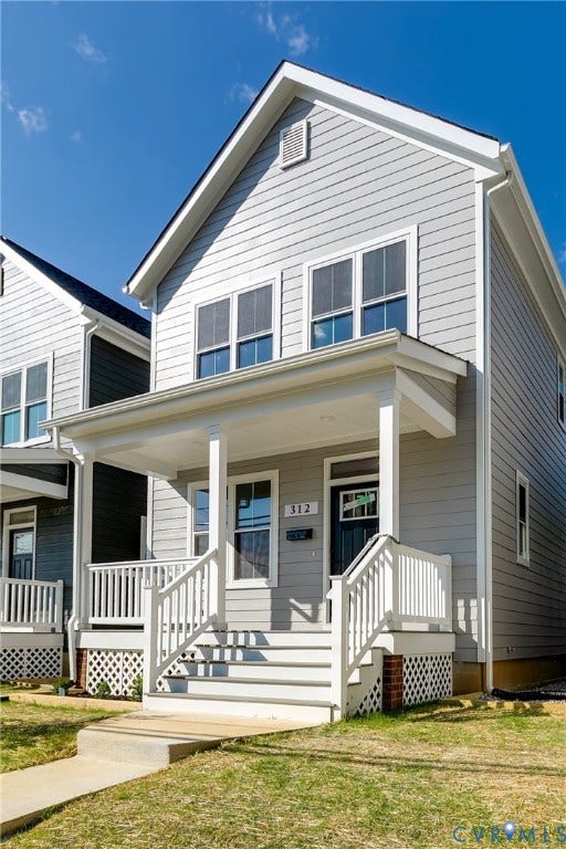 Two-story residence featuring light gray siding, white trim, and a covered front porch with white railings