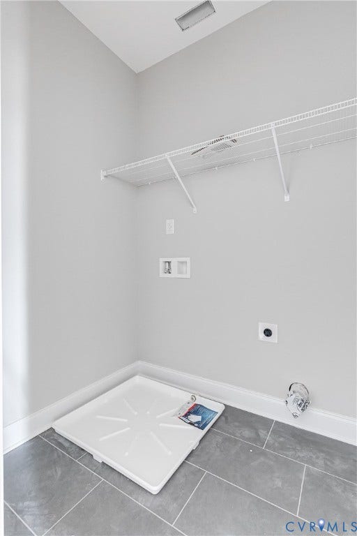 Utility area featuring tile flooring, white wire shelving, and light gray wall paint